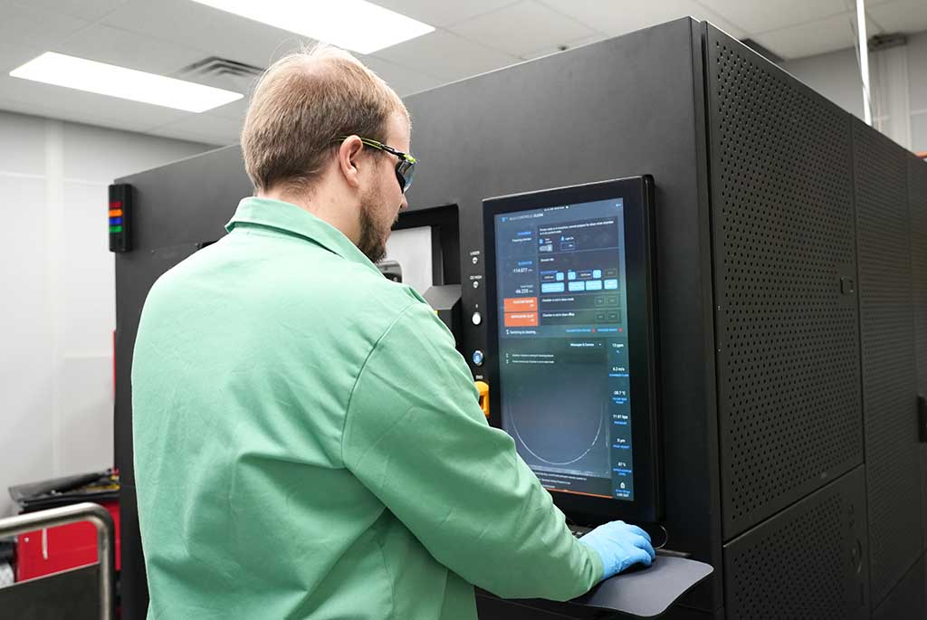 Worker programming a 3D Printer.
